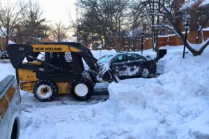 The Absolute Tree team plowing snow in a parking lot in Fairfax, VA.